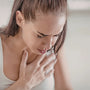 Pregnant woman experiencing heartburn with a glass of water on the table