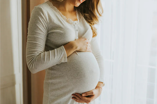 Pregnant woman lying in left lateral position performing a kick count test at home