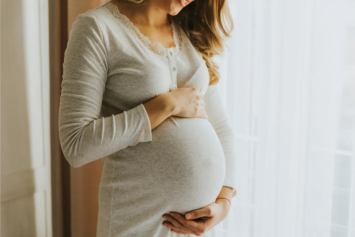 Pregnant woman lying in left lateral position performing a kick count test at home