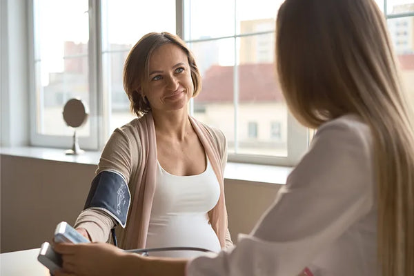 Pregnant woman monitoring blood pressure at home to detect early signs of preeclampsia