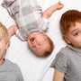 Older child gently touching newborn baby during family bonding moment at home