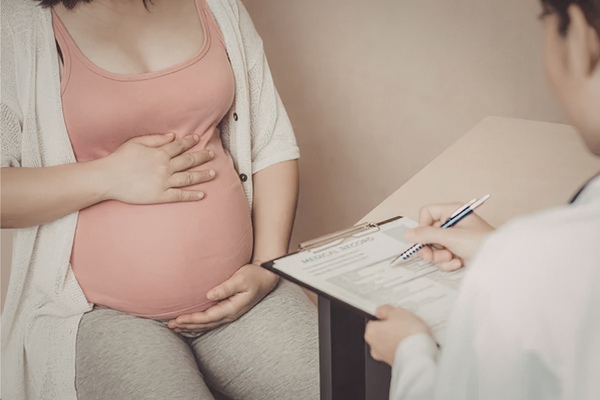 Pregnant woman discussing Group B Strep testing with her doctor during a prenatal visit
