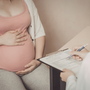 Pregnant woman discussing Group B Strep testing with her doctor during a prenatal visit